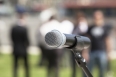 Microphone in focus against blurred audience