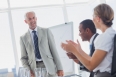 Colleagues applauding smiling manager during a meeting in a meeting room